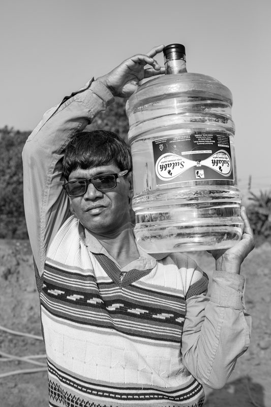 Mrityunjay Bera, resident of Jot Govardhan village - carrying home a 20 liters jar procured from the Sulabh Safe Drinking Water plant in Panchberia village, Paschim Medinipur district, West Bengal
